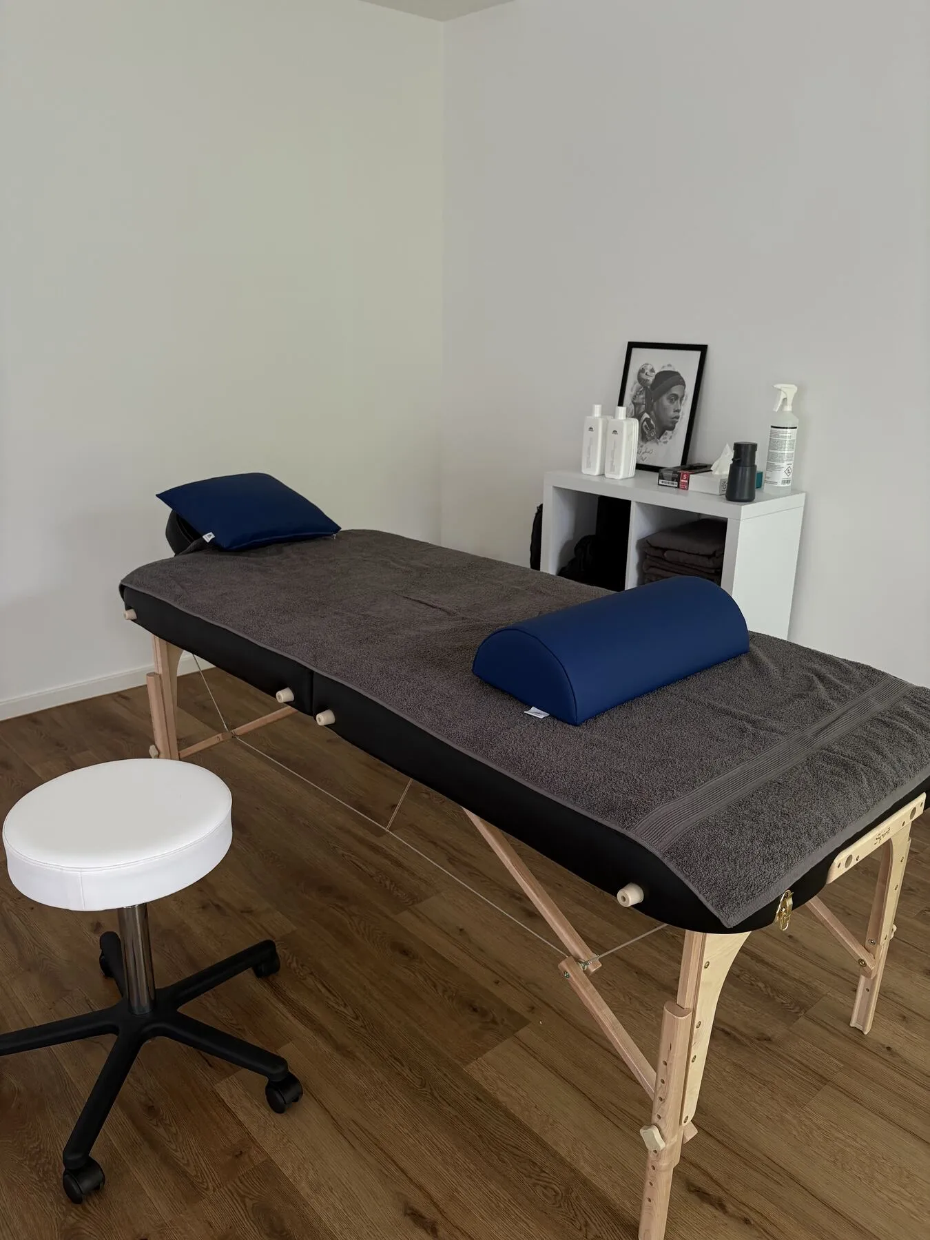 Behandlungsliege der Lumax-Praxis mit Lagerungsrolle und Hocker