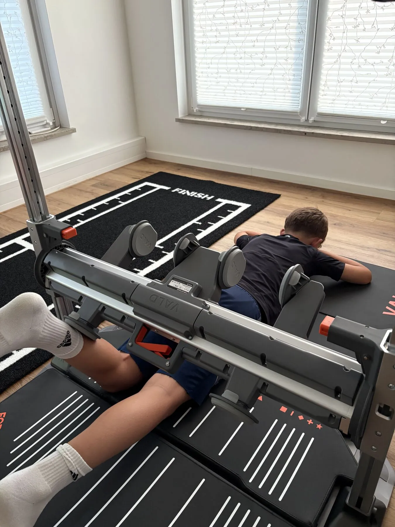 Sportler liegt mit den Beinen im ForceFrame während einer Kraftmessung