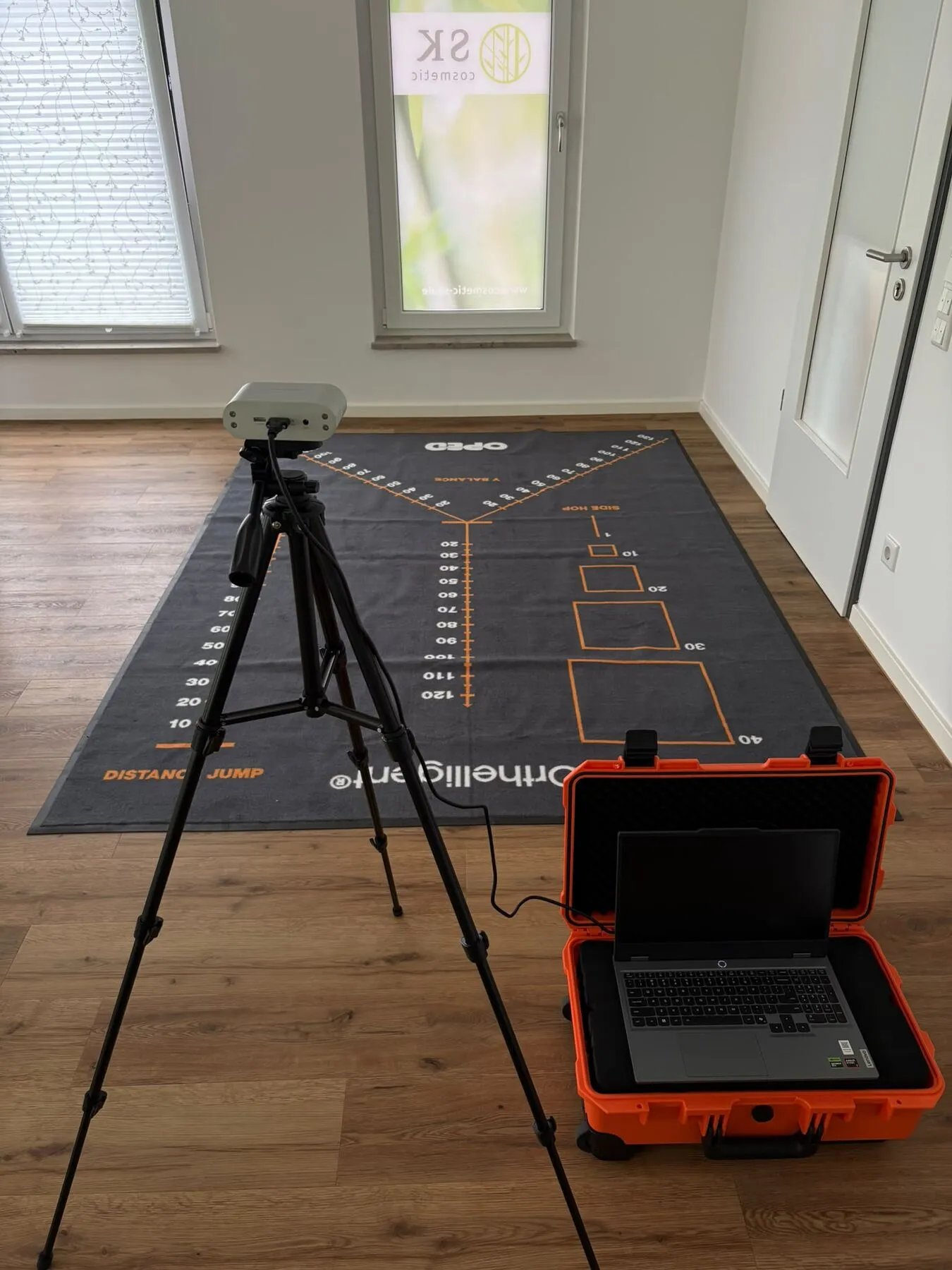 Diagnostikraum mit Kamera-Stativ, Y-Balance-Matte und HumanTrak-Koffer mit Laptop