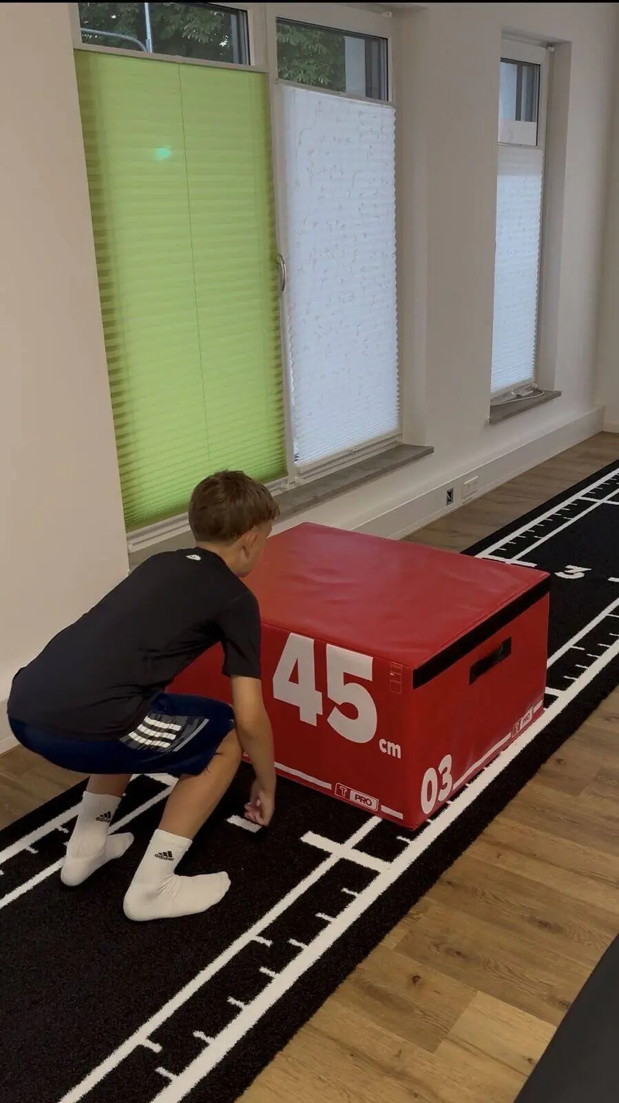 Sportler in der Hocke vor der Plyo-Box beim Sprungtest